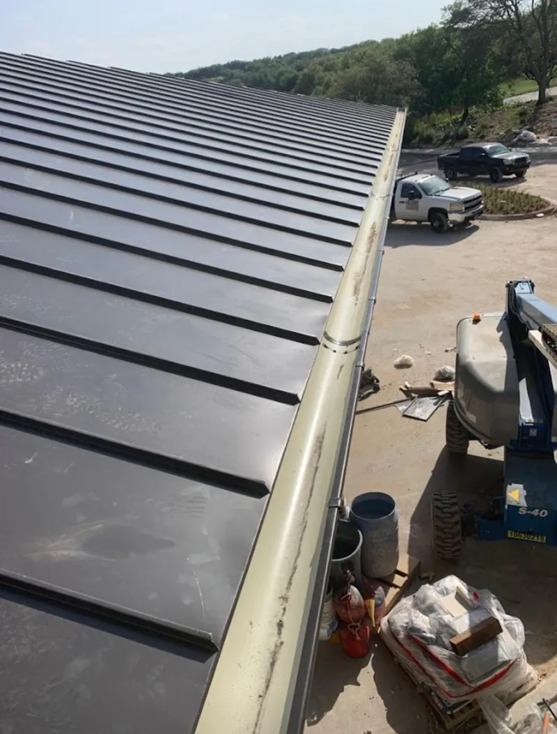 Standing seam panel and gutter detail on a metal roofing jobsite in Cudahy